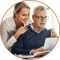 A couple sitting together at a computer, discussing and planning their next chapter after a business transition