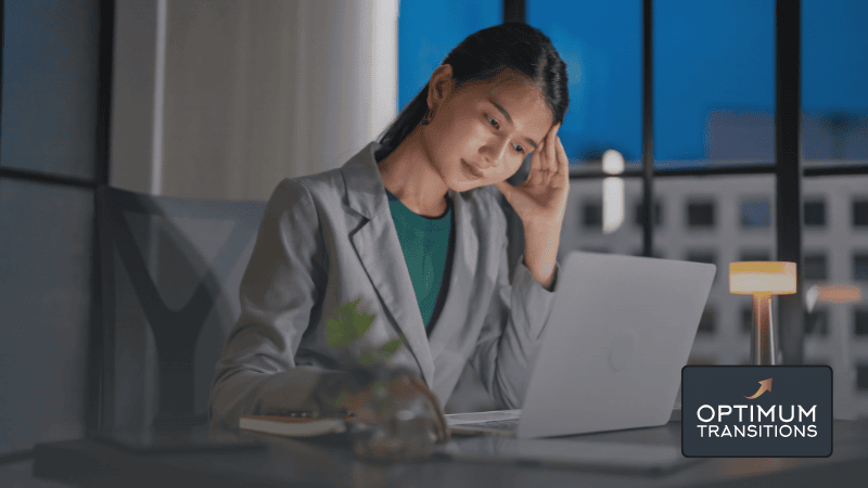 Businesswoman appearing confused or exhausted while working on her laptop, representing the complexity of navigating a solo business sale
