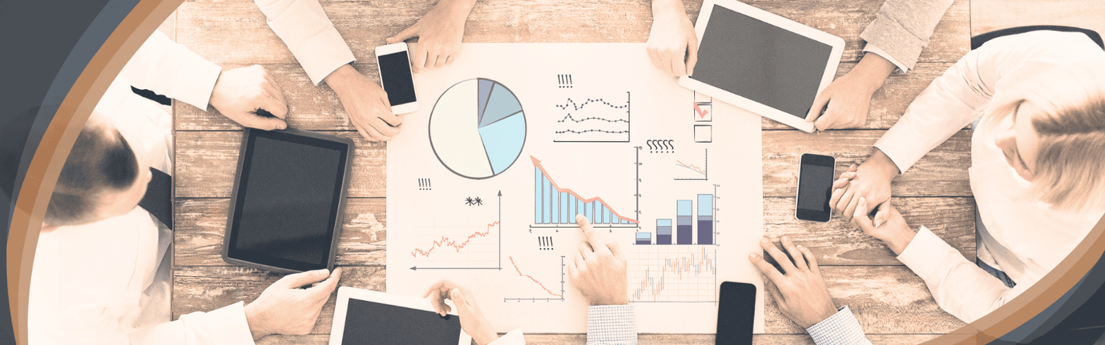 Team gathered around table with laptops and financial charts, symbolizing Optimum Transitions' collaborative process for clarifying goals, evaluating position, creating strategy, and guiding transition execution