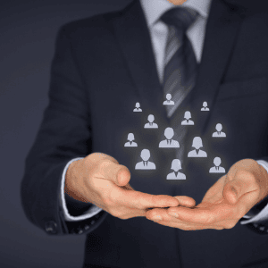 Business professional with open hands virtually holding floating people icons, representing Optimum Transitions' core value of managing the details and coordinating all stakeholders throughout business transitions