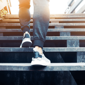 a person walking up stairs with athletic shoes on - representing Optimum Transitions' expertise in guiding transitions step by step