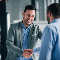 two business people shaking hands in an office representing Optimum Transitions' core value of building trust with integrity
