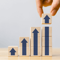A person is placing wooden blocks with arrows on top of them - representing Optimum Transitions' core value of handling the details